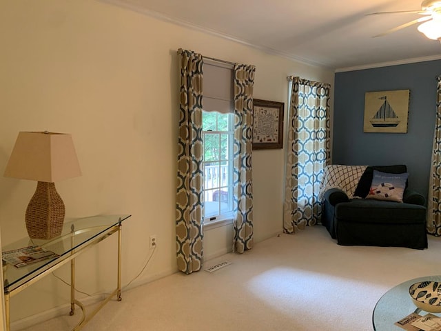 living area featuring crown molding, carpet, and ceiling fan