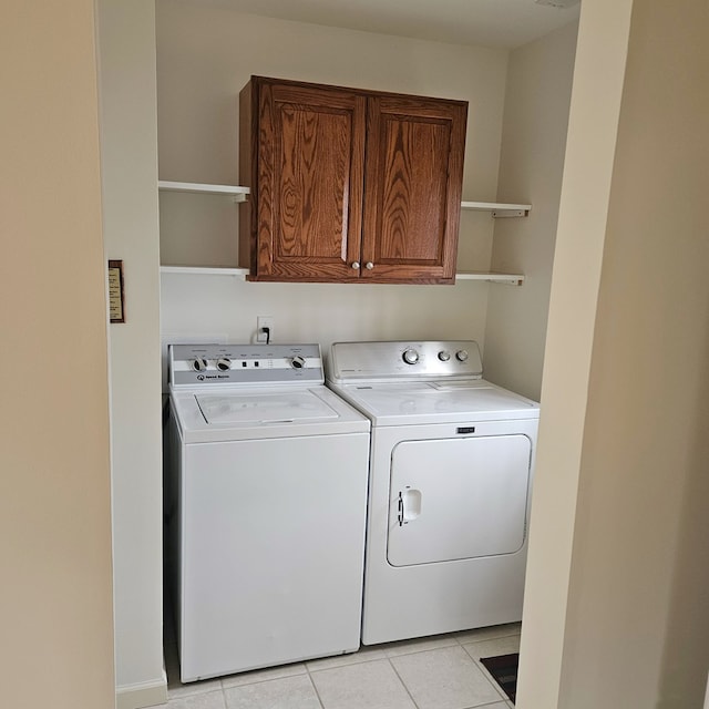 laundry area featuring cabinet space, washing machine and dryer, and light tile patterned floors