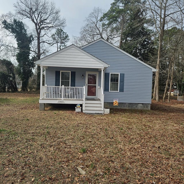 bungalow-style house featuring covered porch and a front yard