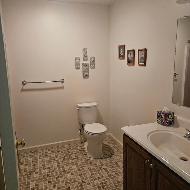 bathroom with vanity, toilet, and baseboards