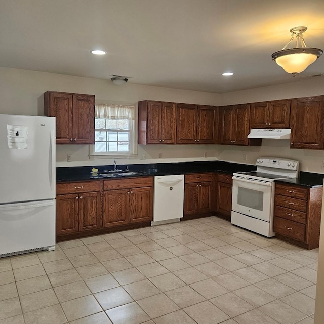 kitchen with recessed lighting, under cabinet range hood, white appliances, a sink, and dark countertops