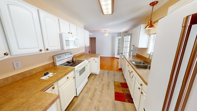 kitchen featuring white cabinetry, sink, kitchen peninsula, pendant lighting, and white appliances