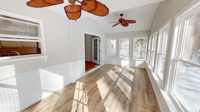 unfurnished sunroom with ceiling fan, sink, and vaulted ceiling