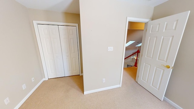 unfurnished bedroom featuring light carpet and a closet