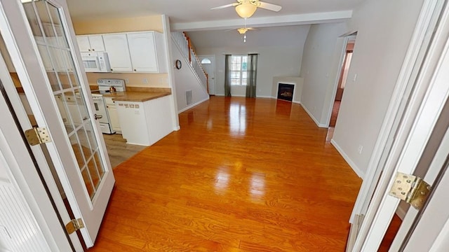 interior space with light hardwood / wood-style floors and beam ceiling