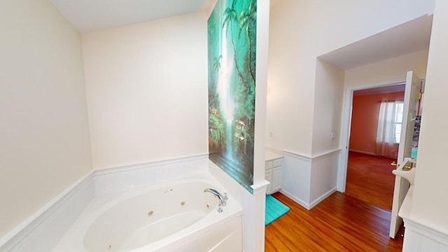 bathroom with a tub to relax in and hardwood / wood-style floors