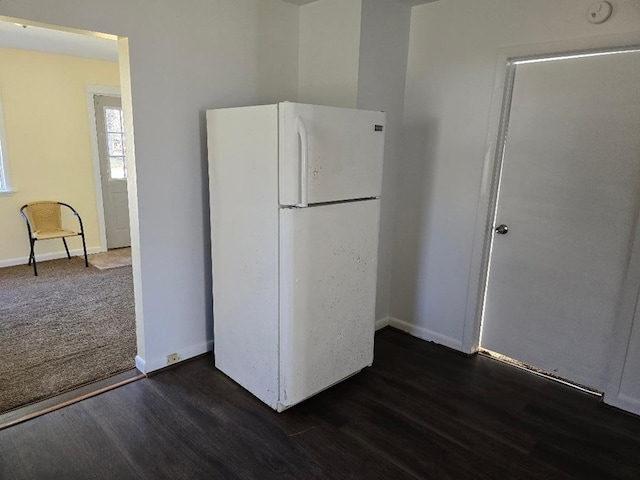 kitchen with white fridge and dark wood-type flooring
