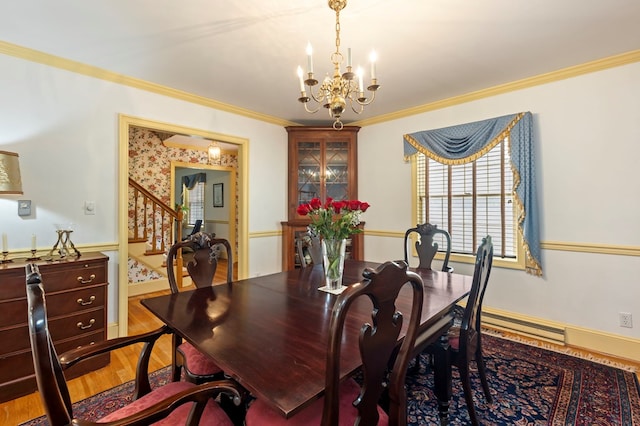 dining area with a chandelier, hardwood / wood-style floors, and ornamental molding