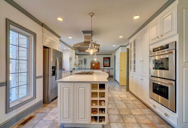 kitchen featuring stainless steel appliances, crown molding, pendant lighting, white cabinetry, and a kitchen island