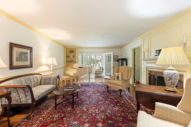 living room with hardwood / wood-style flooring, built in features, and crown molding