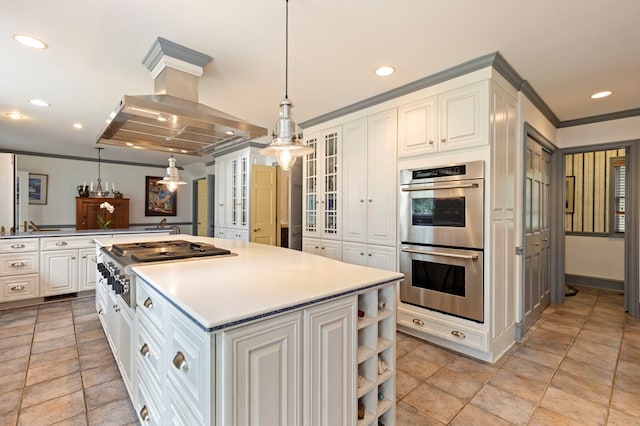 kitchen featuring island exhaust hood, appliances with stainless steel finishes, decorative light fixtures, a center island, and white cabinetry