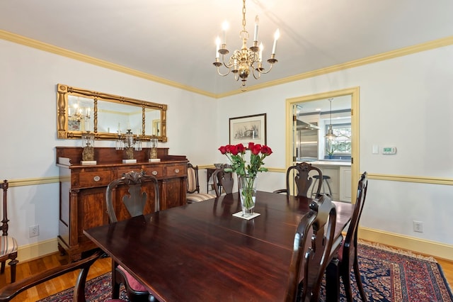 dining area with a chandelier, hardwood / wood-style flooring, and crown molding