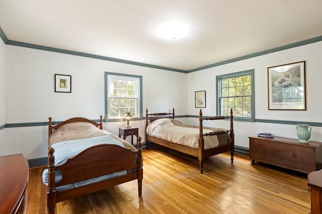 bedroom featuring light hardwood / wood-style flooring and crown molding