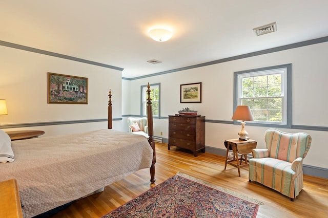 bedroom featuring light wood-type flooring and ornamental molding