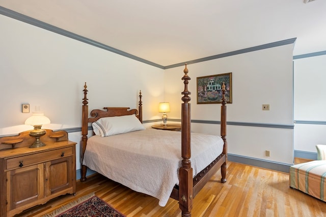 bedroom with light hardwood / wood-style floors and crown molding