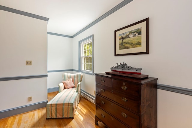 sitting room featuring light hardwood / wood-style floors and crown molding