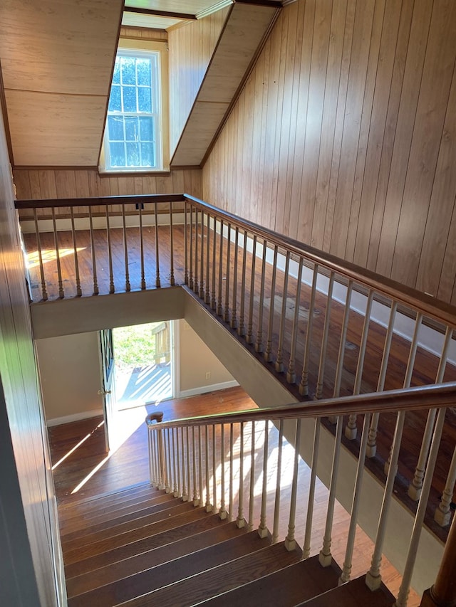 stairs featuring wood walls and wood-type flooring