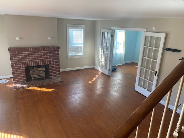 unfurnished living room with a fireplace and dark wood-type flooring