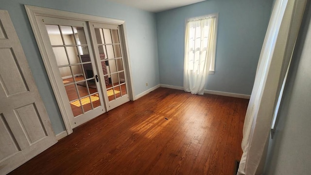 empty room with dark hardwood / wood-style flooring and french doors