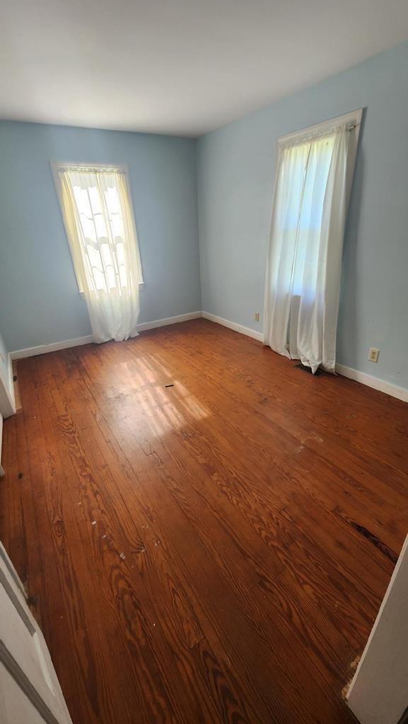 unfurnished room with hardwood / wood-style flooring