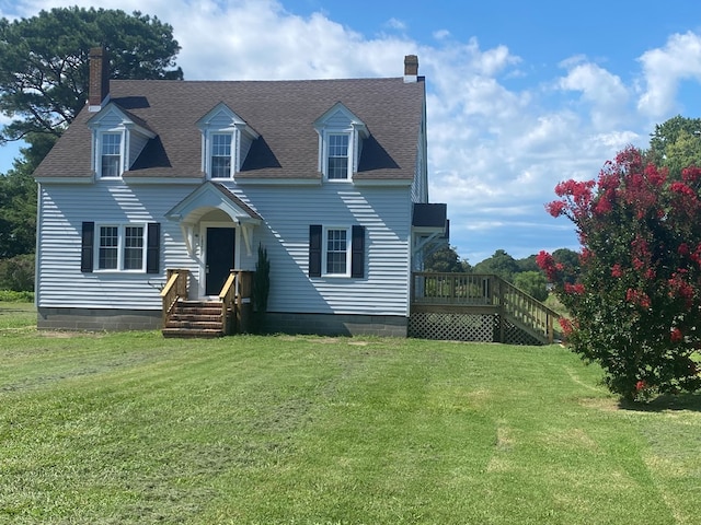 cape cod house featuring a front yard