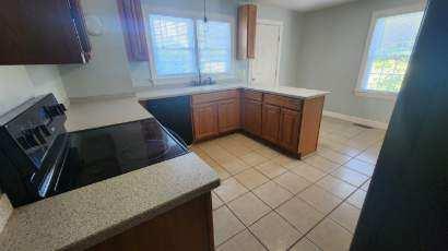 kitchen with kitchen peninsula, stove, and light tile patterned floors