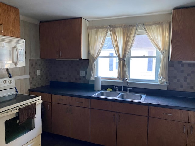 kitchen featuring backsplash, sink, and white appliances