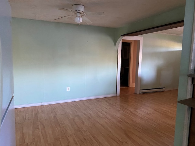 empty room featuring ceiling fan, light wood-type flooring, and a baseboard radiator