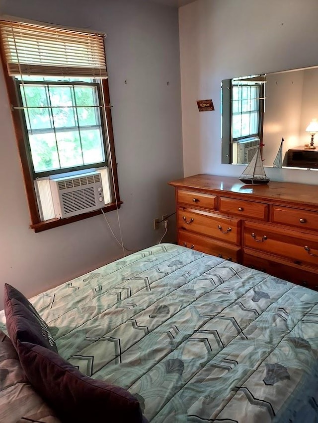 bedroom with cooling unit and multiple windows