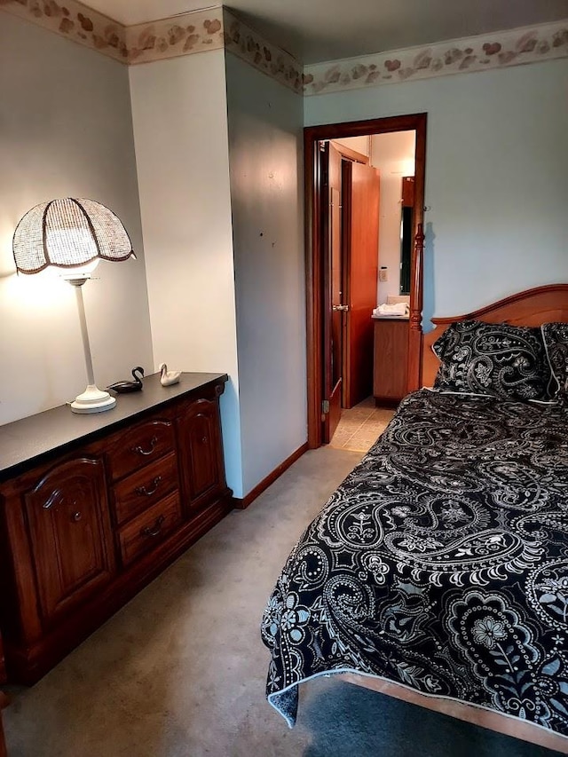 carpeted bedroom featuring ensuite bath