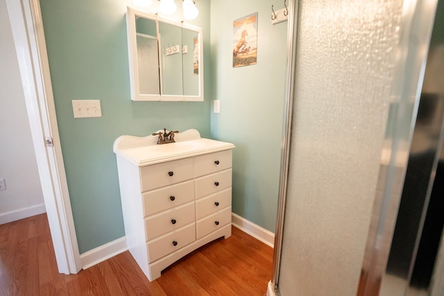 bathroom featuring baseboards, wood finished floors, and vanity