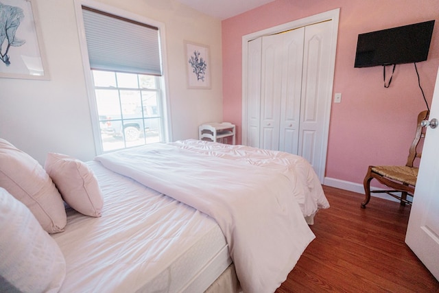 bedroom with a closet, baseboards, and wood finished floors