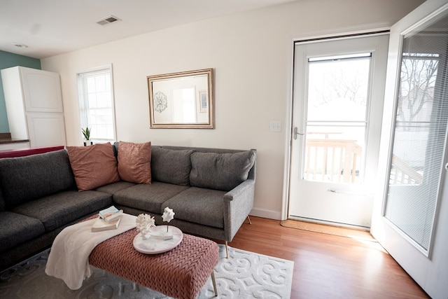 living room featuring visible vents, baseboards, and light wood-style flooring