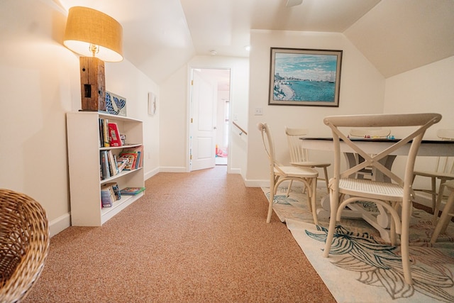 interior space featuring baseboards, lofted ceiling, and carpet flooring