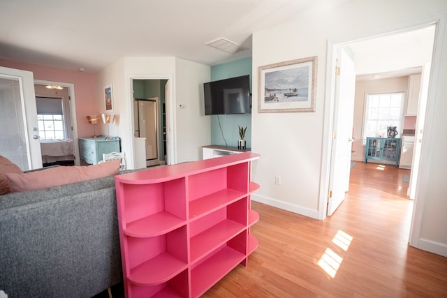 living area featuring visible vents, baseboards, and light wood-type flooring