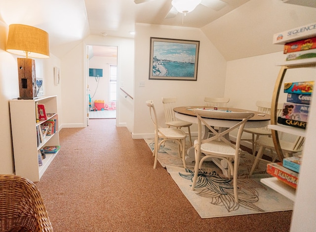 carpeted dining area featuring lofted ceiling, baseboards, and ceiling fan