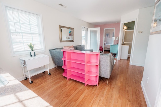 interior space with baseboards, visible vents, and light wood finished floors