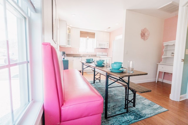 dining area featuring visible vents, light wood-style flooring, and baseboards