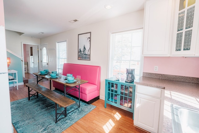 dining room with baseboards, plenty of natural light, and light wood-style flooring