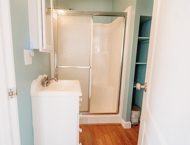 bathroom featuring a stall shower, vanity, and wood finished floors