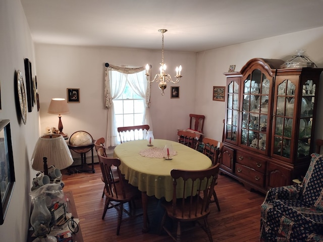 dining space with dark hardwood / wood-style flooring and a notable chandelier