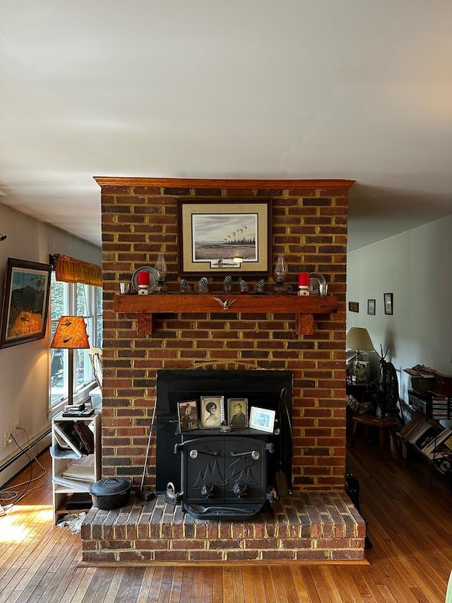 room details featuring a wood stove, a baseboard radiator, and hardwood / wood-style flooring