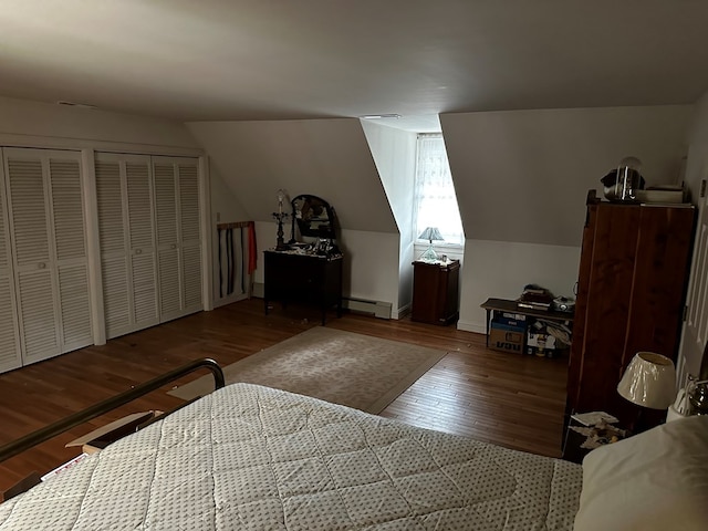 bedroom featuring wood-type flooring, two closets, a baseboard radiator, and lofted ceiling