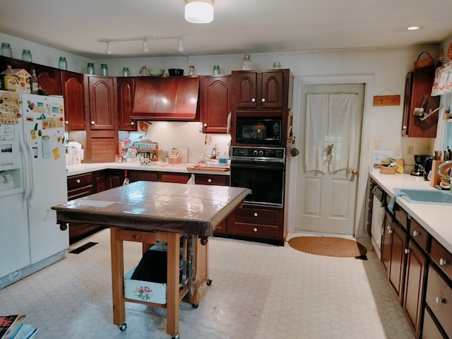 kitchen with premium range hood, sink, black appliances, and track lighting