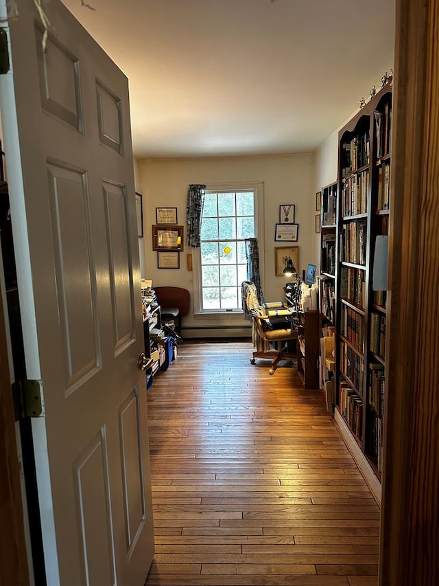 home office with baseboard heating and wood-type flooring