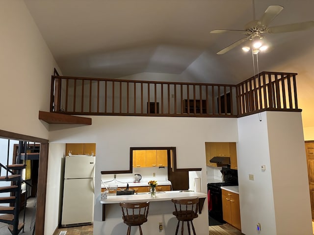 26491 Mason Rd, Bloxom, VA 23308 - kitchen with ceiling fan, black range with electric cooktop, a kitchen breakfast bar, high vaulted ceiling, and white refrigerator