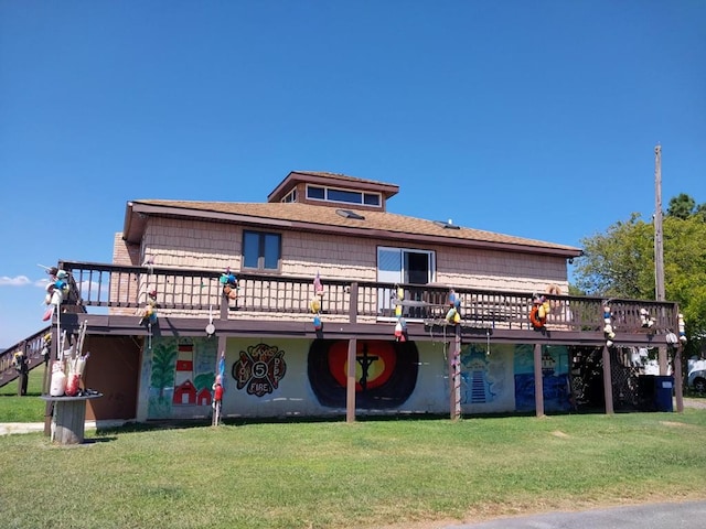 back of property with a yard and a wooden deck