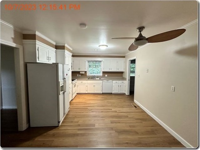 kitchen featuring white appliances, sink, crown molding, ceiling fan, and white cabinetry