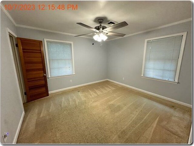 unfurnished bedroom with ceiling fan, light colored carpet, and crown molding