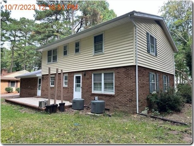 rear view of property featuring a patio, a lawn, and central air condition unit